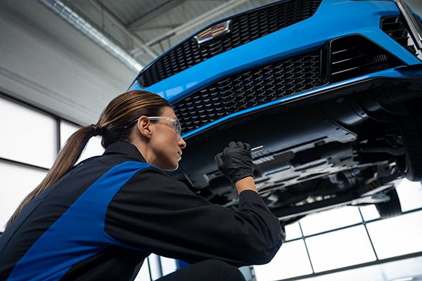 Service technician inspecting a vehicle- Tom Clark Cadillac in Denton TX