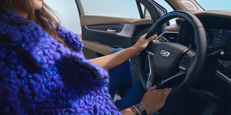 woman driving her Cadillac XT6 on the road - Tom Clark Cadillac in Denton TX
