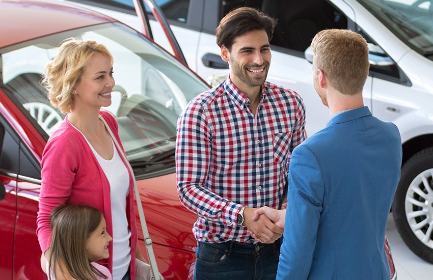 Sales representative greeting a family - Tom Clark Cadillac in Denton TX