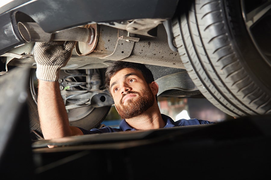 Service technician checking out the car exhaust - Tom Clark Cadillac in Denton TX